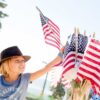 Photo of child reaching for a US flag for post about Independence Day 2023 - Toward a more perfect union